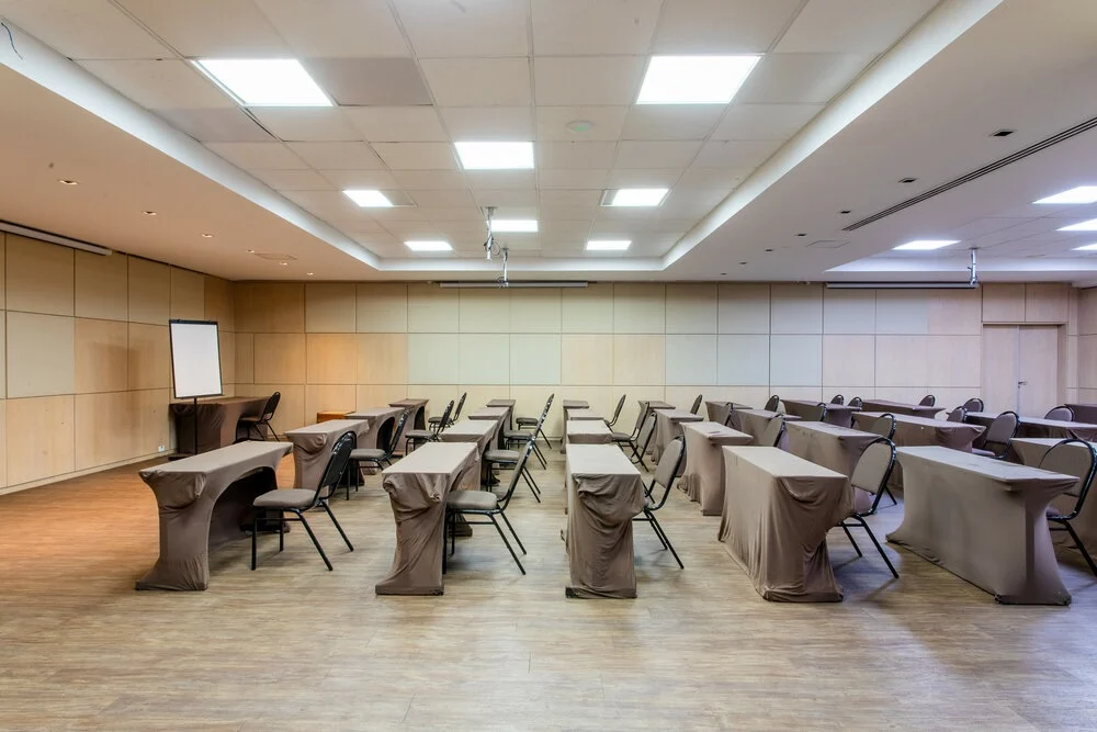 Sala de eventos ampla montada em formato escolar